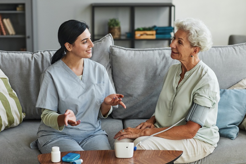 Young Nurse Talking to Senior Woman in Retirement Home